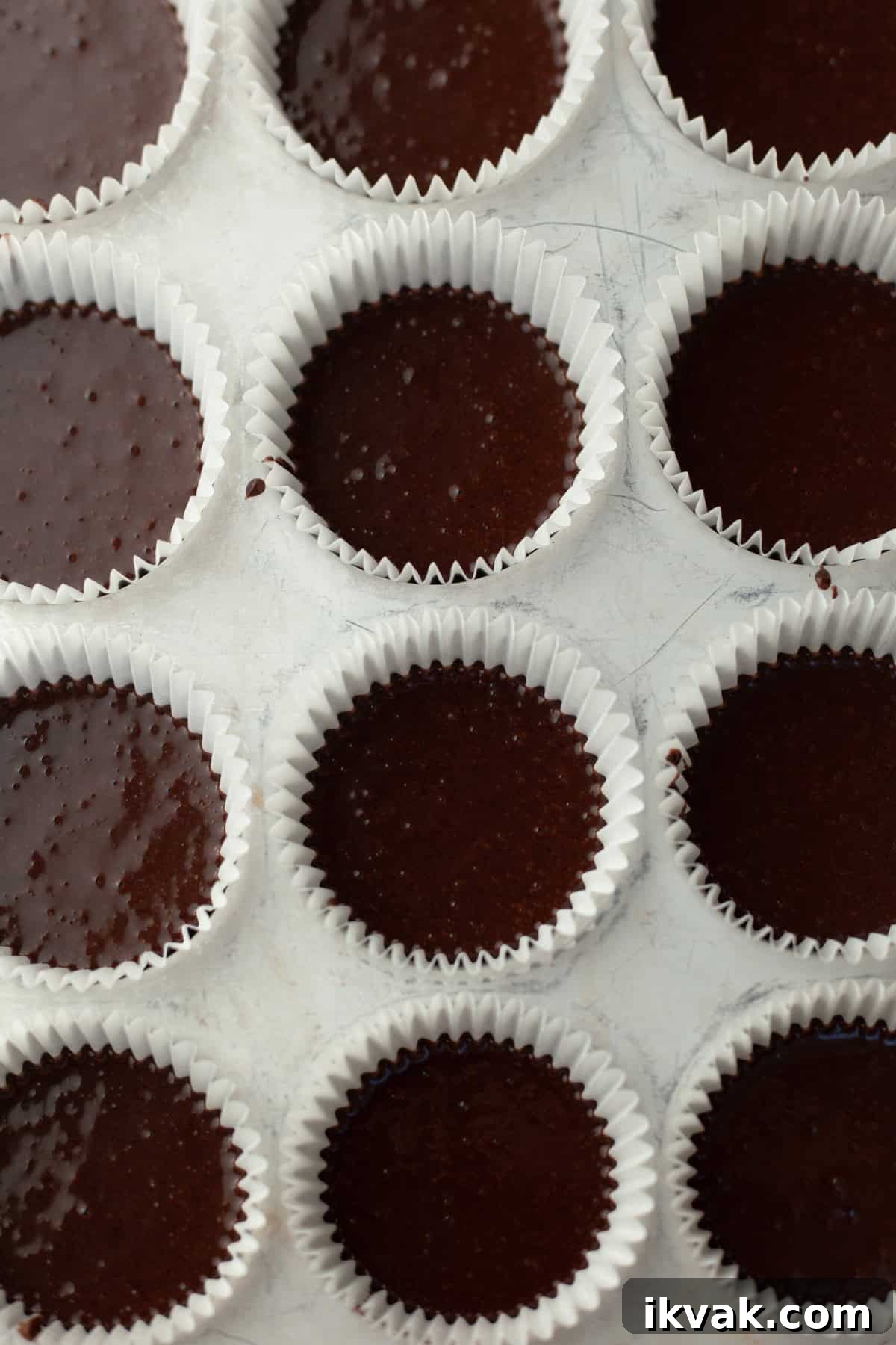 Unbaked chocolate cupcakes in a cupcake tin.