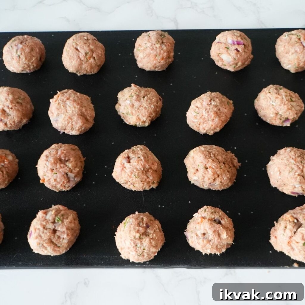Greek turkey meatballs on a cutting board before cooking.