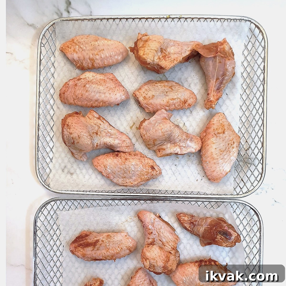 Chicken wings arranged on trays ready to be air-fried.