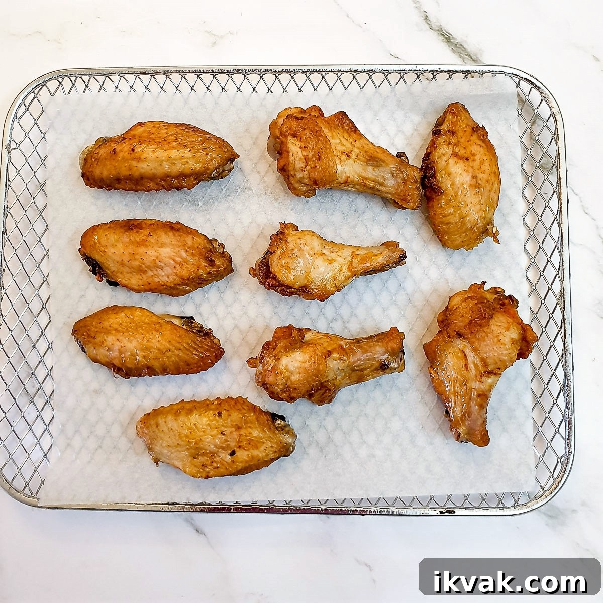 Golden brown air-fried chicken wings on a baking tray.