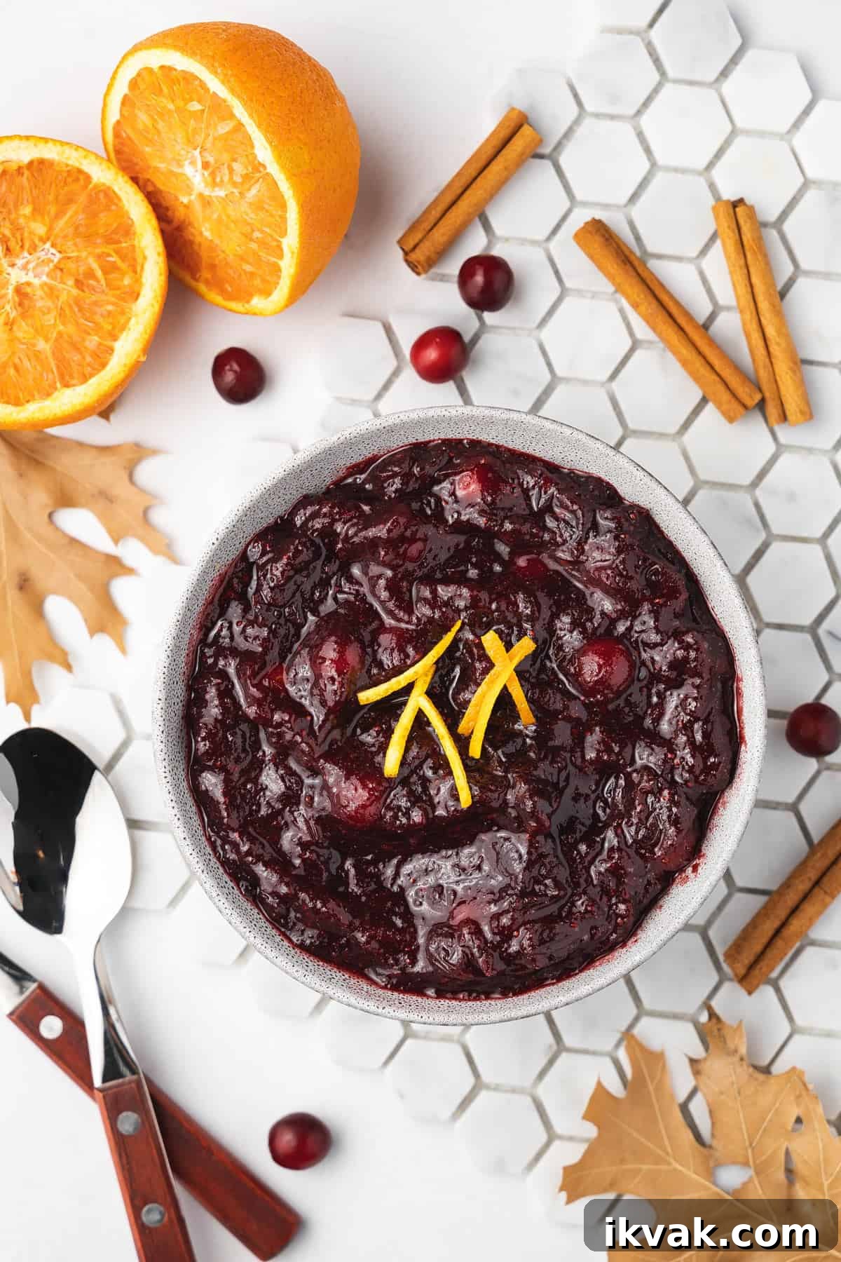Overhead view of a bowl of slow cooker cranberry sauce with orange zest as garnish.