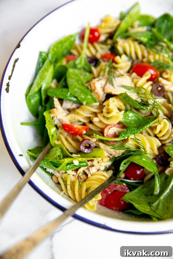 Close up side view of the tuna pasta salad in a mixing bowl. 