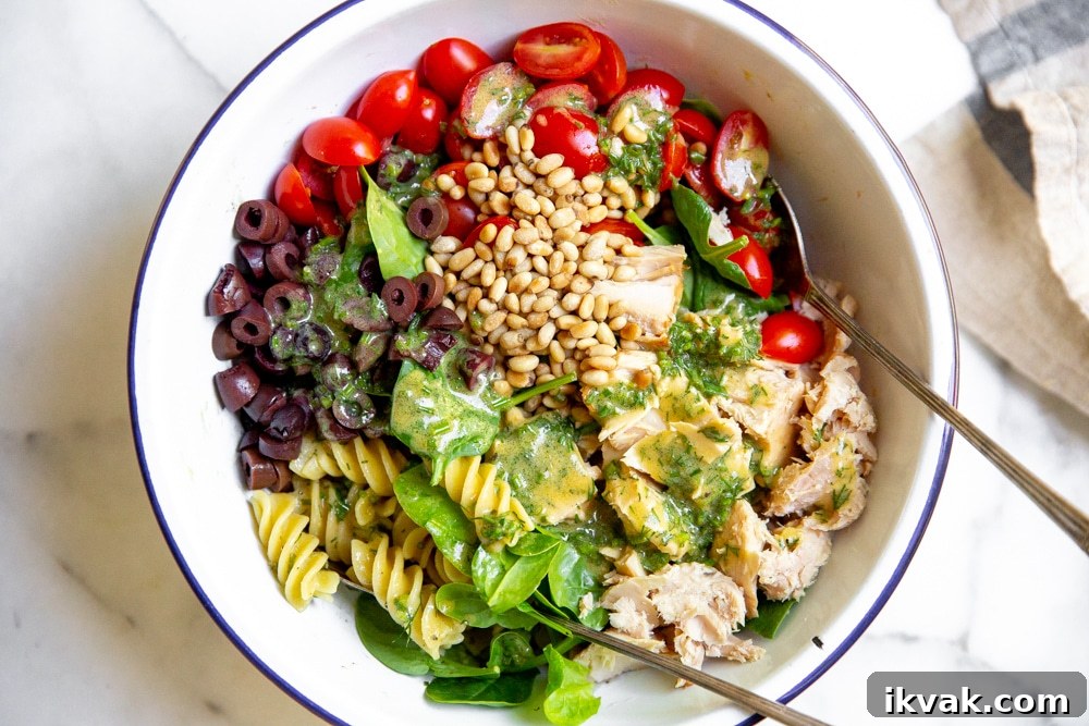Process shot showing all of the ingredients for the healthy tuna pasta salad recipe layered in a large bowl. 
