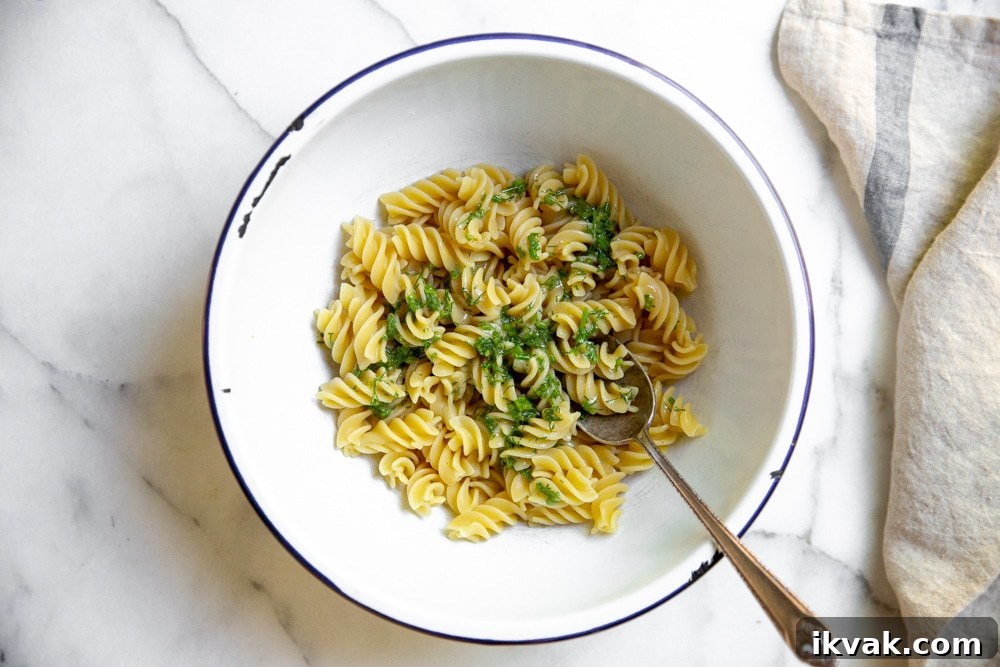 Cooked pasta with dressing in a bowl for the healthy tuna pasta salad. 