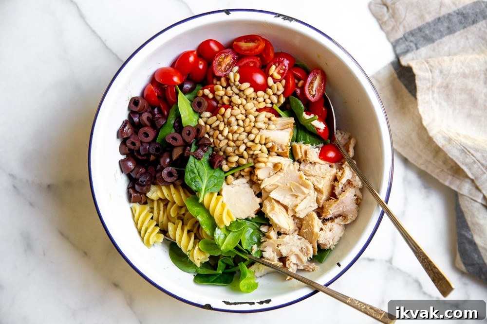 All of the ingredients for the pasta salad layered in a large bowl.