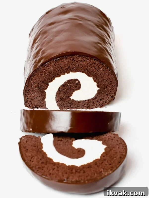 chocolate roll cake, swiss roll cake filled with cream and covered in a chocolate ganache glaze