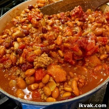 A large stockpot on the stove full of chili.
