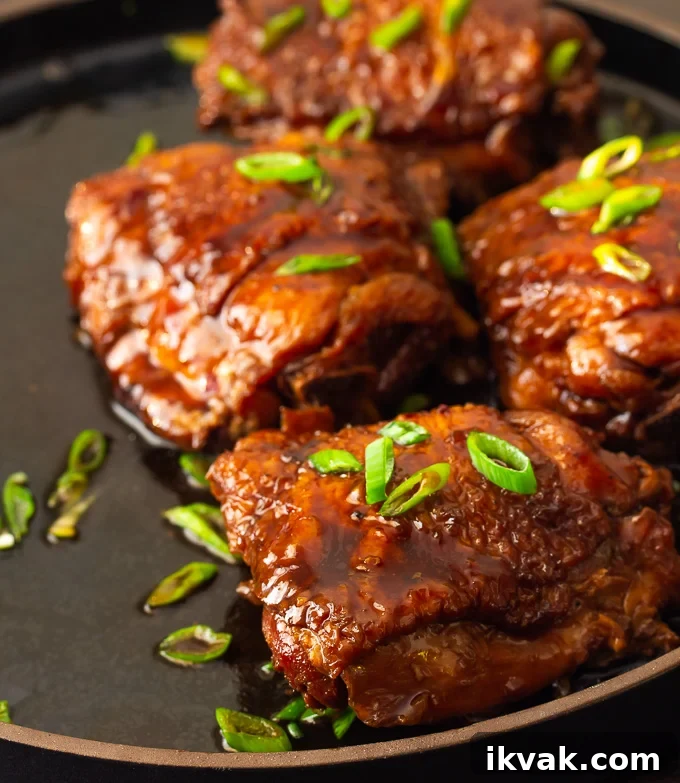 A plate of shoyu chicken simmered in a savory soy-based sauce with the sauce poured over the chicken.
