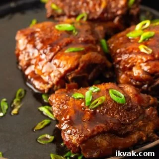 A plate of shoyu chicken served with sauce.