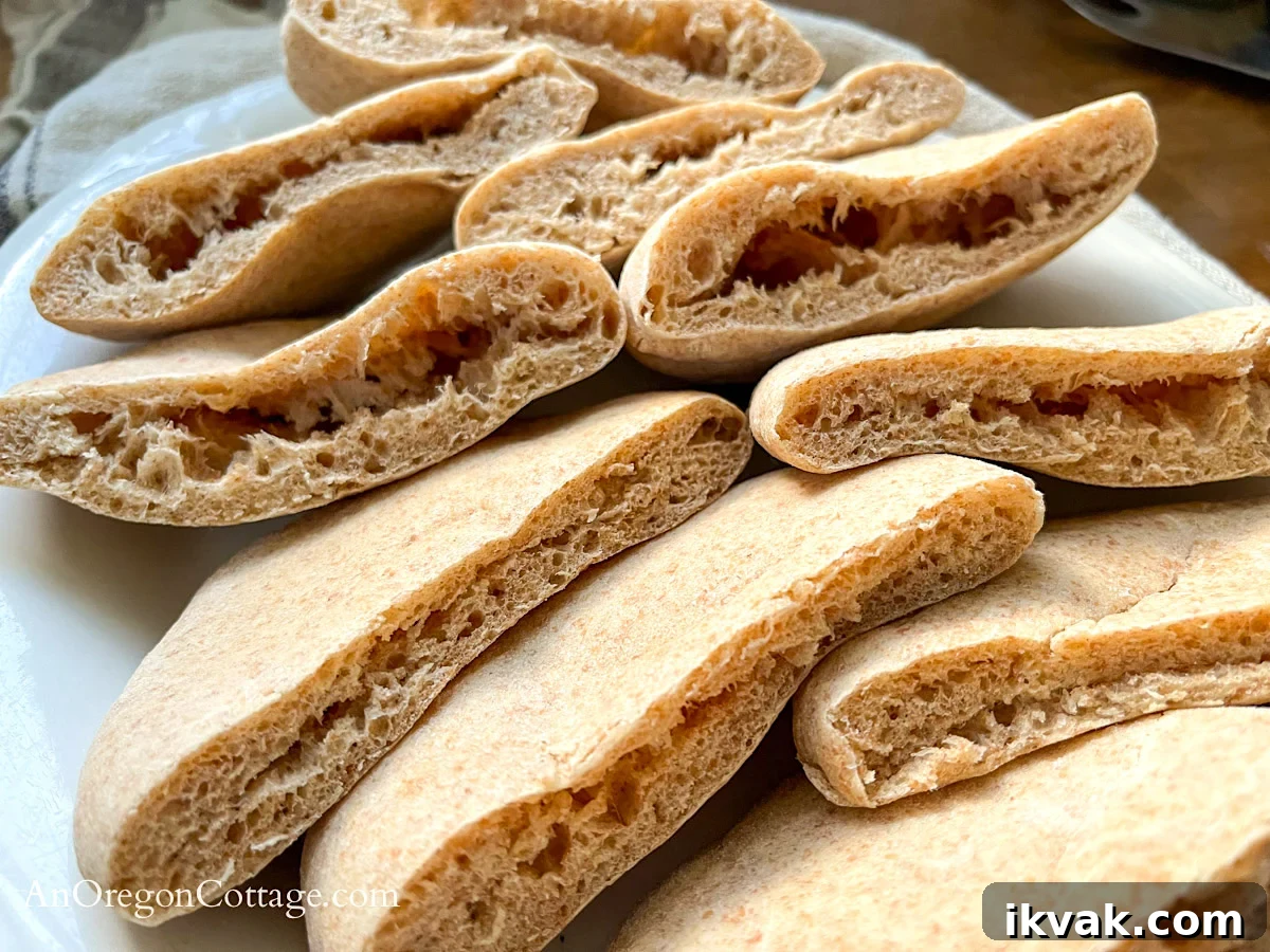 Homemade Whole Wheat Pita Bread Recipe — Soft & Fluffy 3 cut pita bread on white platter close