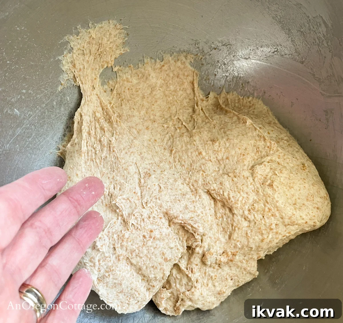 Homemade Whole Wheat Pita Bread Recipe — Soft & Fluffy 7 tacky kneaded pita dough on finger and sticking to bottom of bowl