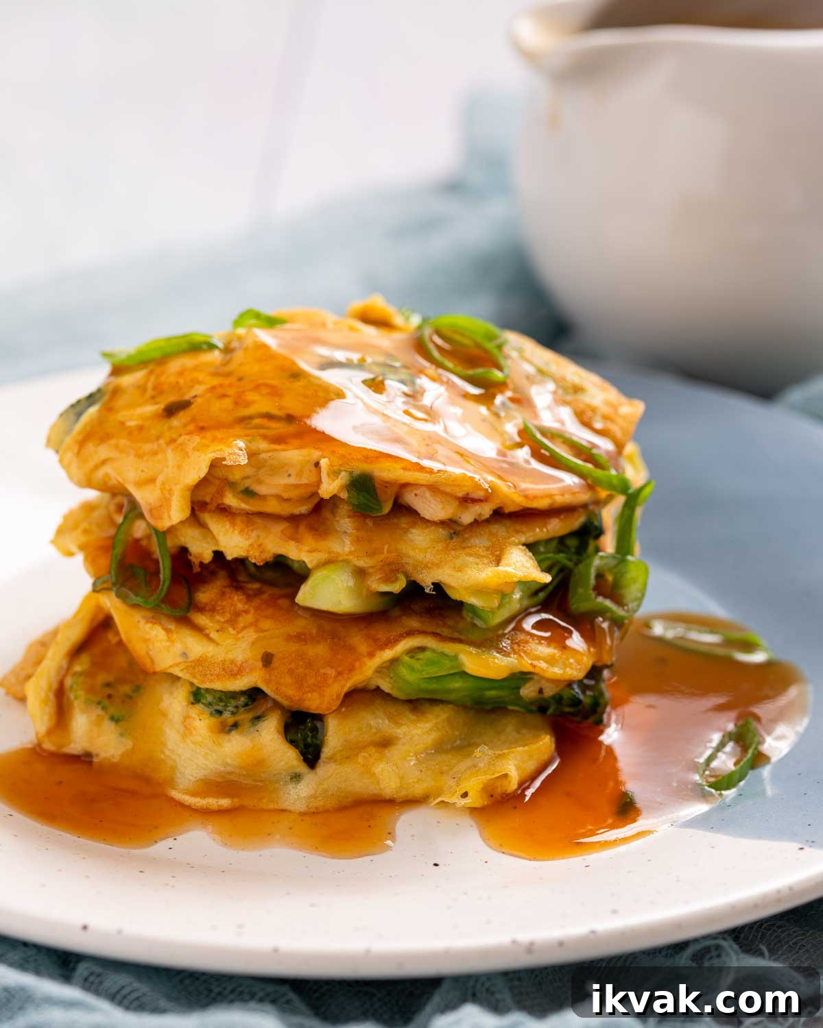 Keto Egg Foo Young Recipe: Low-Carb Chinese-Style Omelette 2 A stack of egg foo young patties covered in gravy.