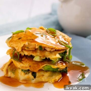Keto Egg Foo Young Recipe: Low-Carb Chinese-Style Omelette 16 A stack of egg foo young patties covered in gravy.