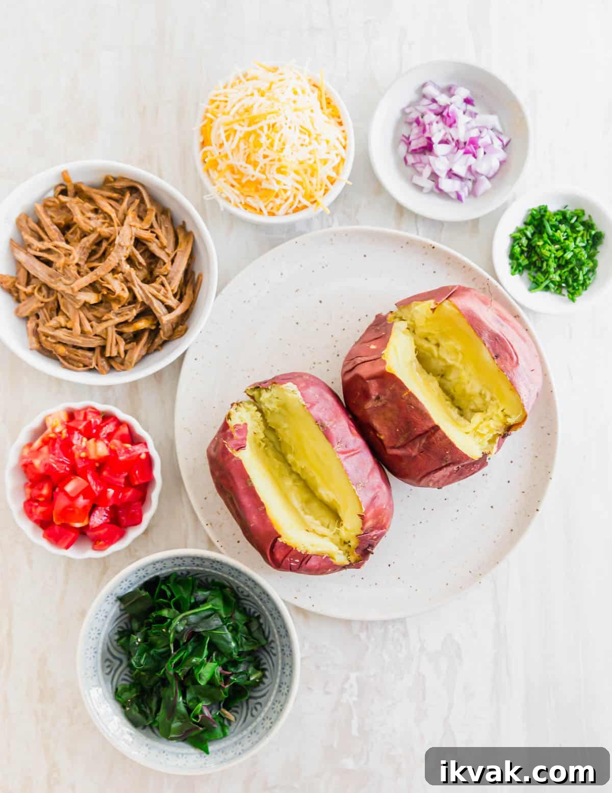 Ingredients needed to make brisket baked potatoes - leftover cooked and shredded beef brisket, cheese, red onion, tomato, greens and chives.