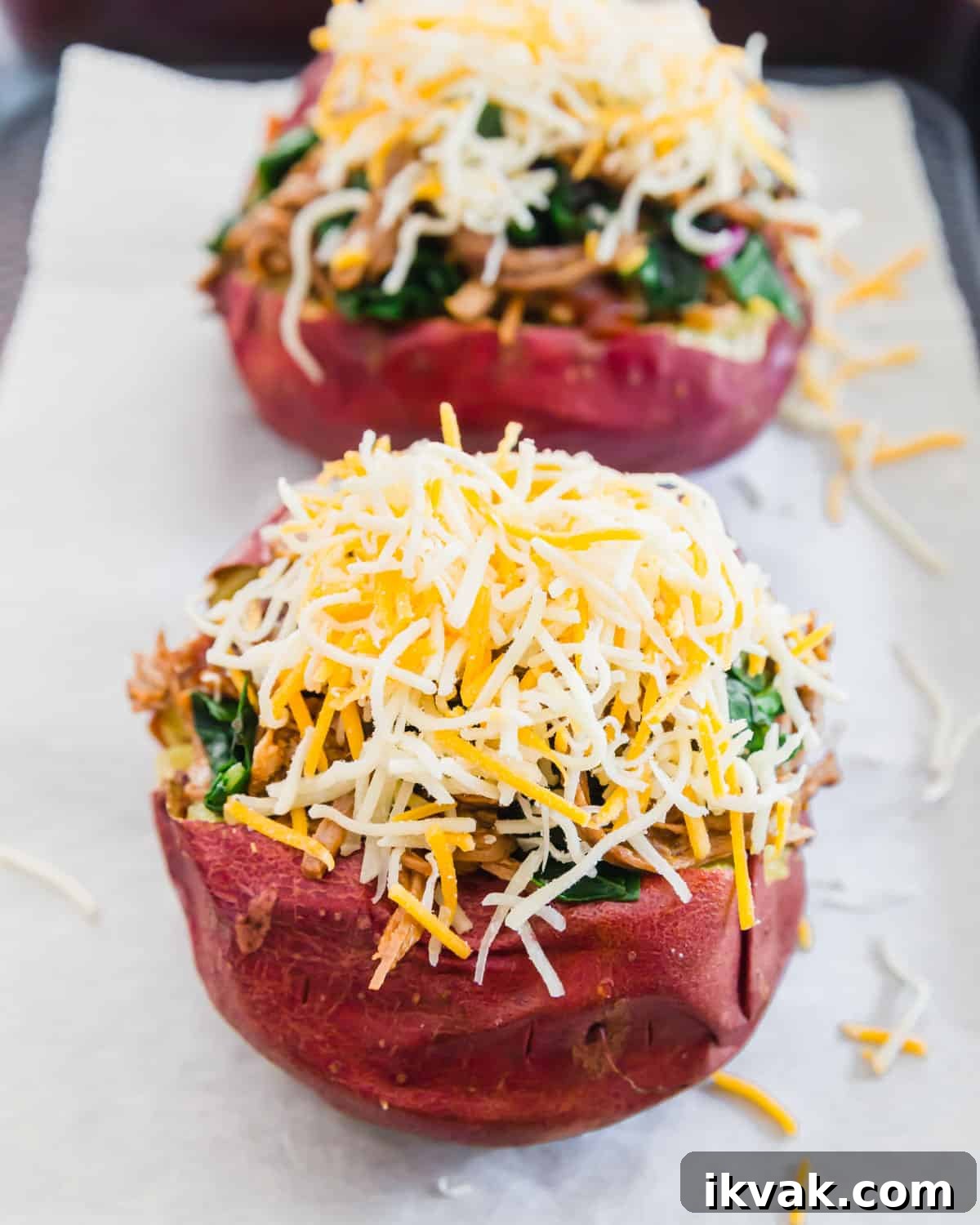 brisket stuffed potatoes before baking topped with lots of shredded cheddar cheese