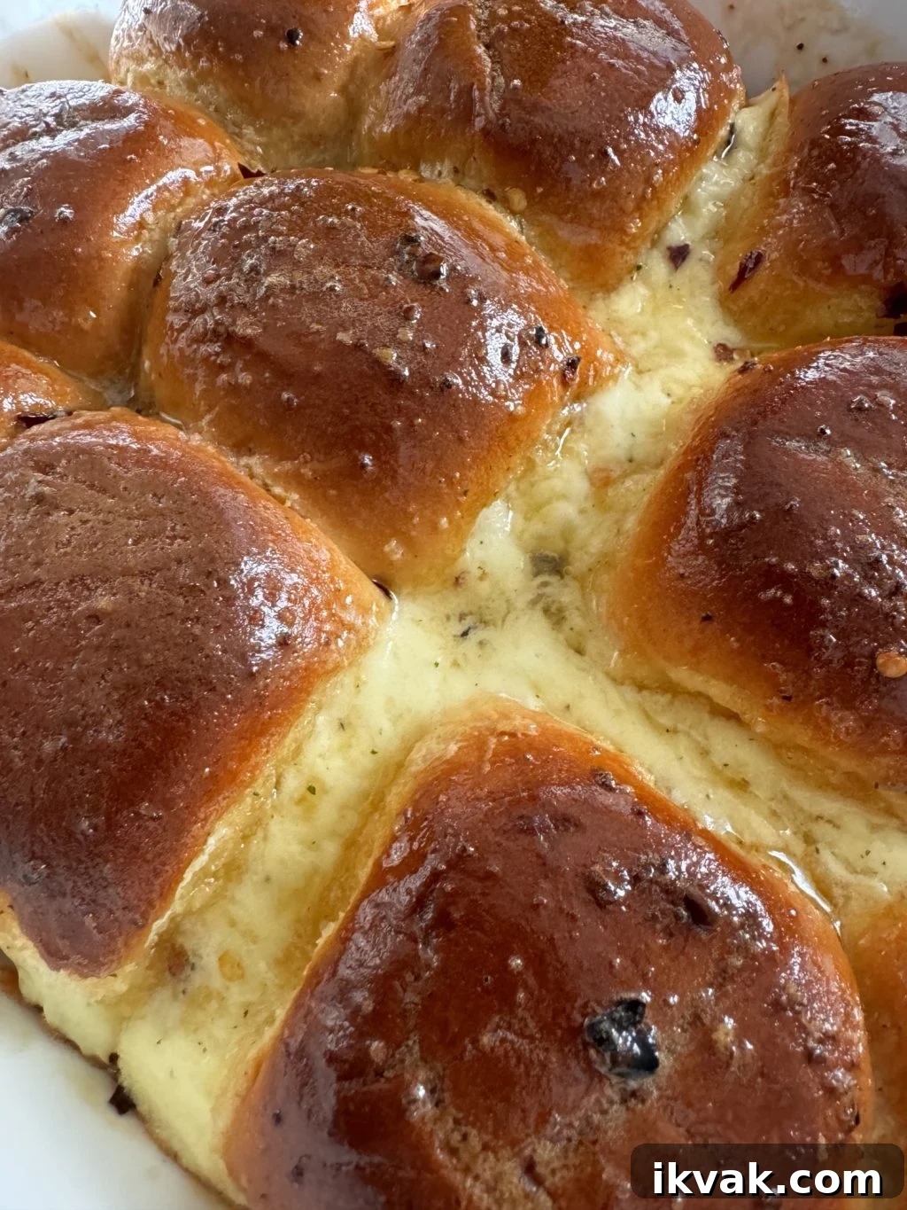 A close up of honeyed rolls with cheese oozing out in between.
