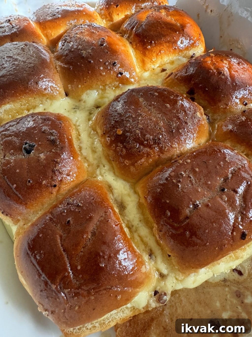 A close up of honeyed rolls with cheese oozing out in between.