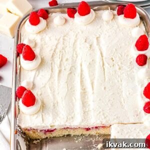 The finished white chocolate raspberry cake in a 9 by 13 inch pan and cut into so you can see what the inside looks like.