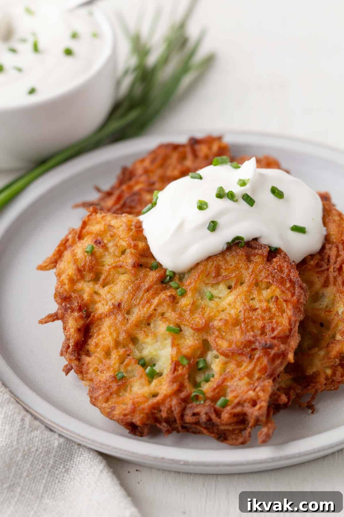 Crispy Potato Pancakes Recipe: Golden Hash Browns from Scratch 12 crispy potato pancakes topped with a dollop of sour cream and chopped chives.