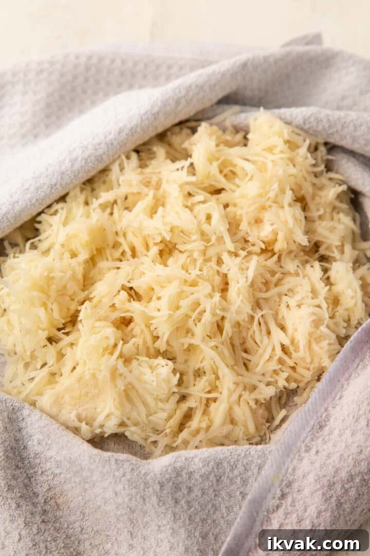 Crispy Potato Pancakes Recipe: Golden Hash Browns from Scratch 7 shredded potatoes inside a kitchen towel.