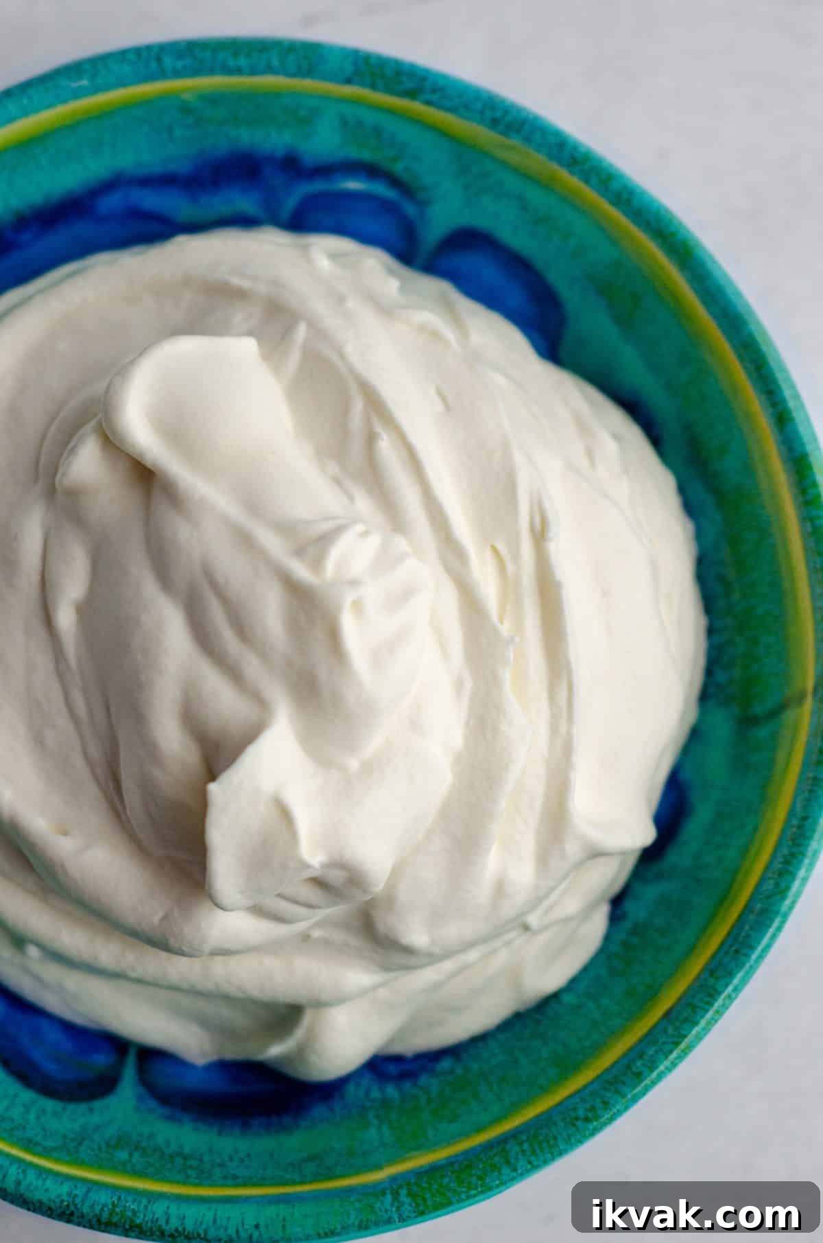 homemade whipped cream in a blue and green bowl