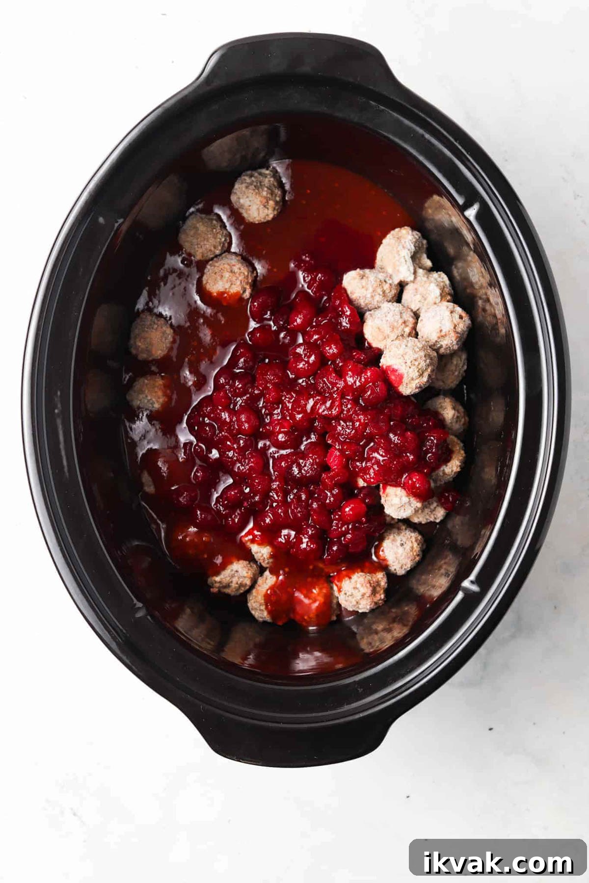 Sweet Cranberry BBQ Meatballs for Parties and Weeknights 4 Cranberry BBQ meatball ingredients in a crockpot base unmixed.