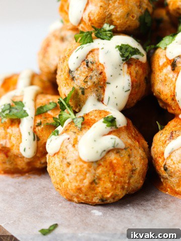 buffalo chicken meatballs stacked on top of each other with whole30 ranch and parsley