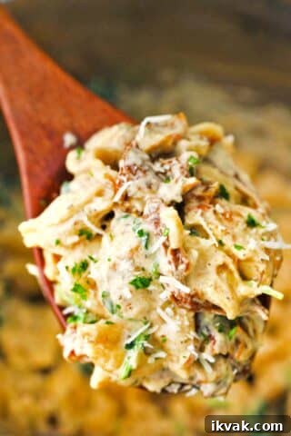 a serving wooden spoon with instant pot tuscan chicken pasta