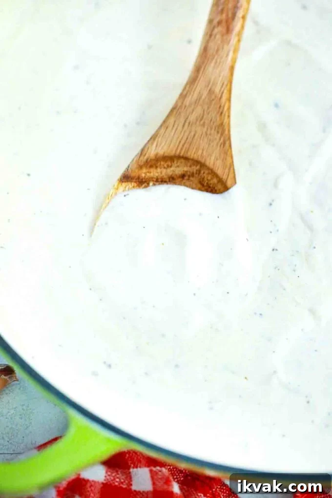 Creamy Homemade Alfredo Sauce Recipe for Pasta Night 8 stirring creamy Alfredo sauce in a pan