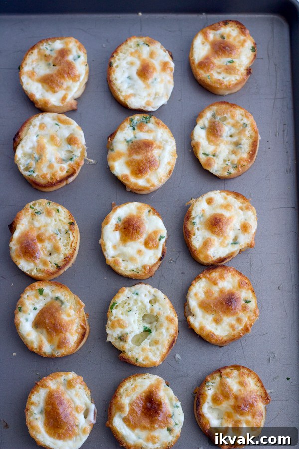 Cheesy baguette on baking sheet