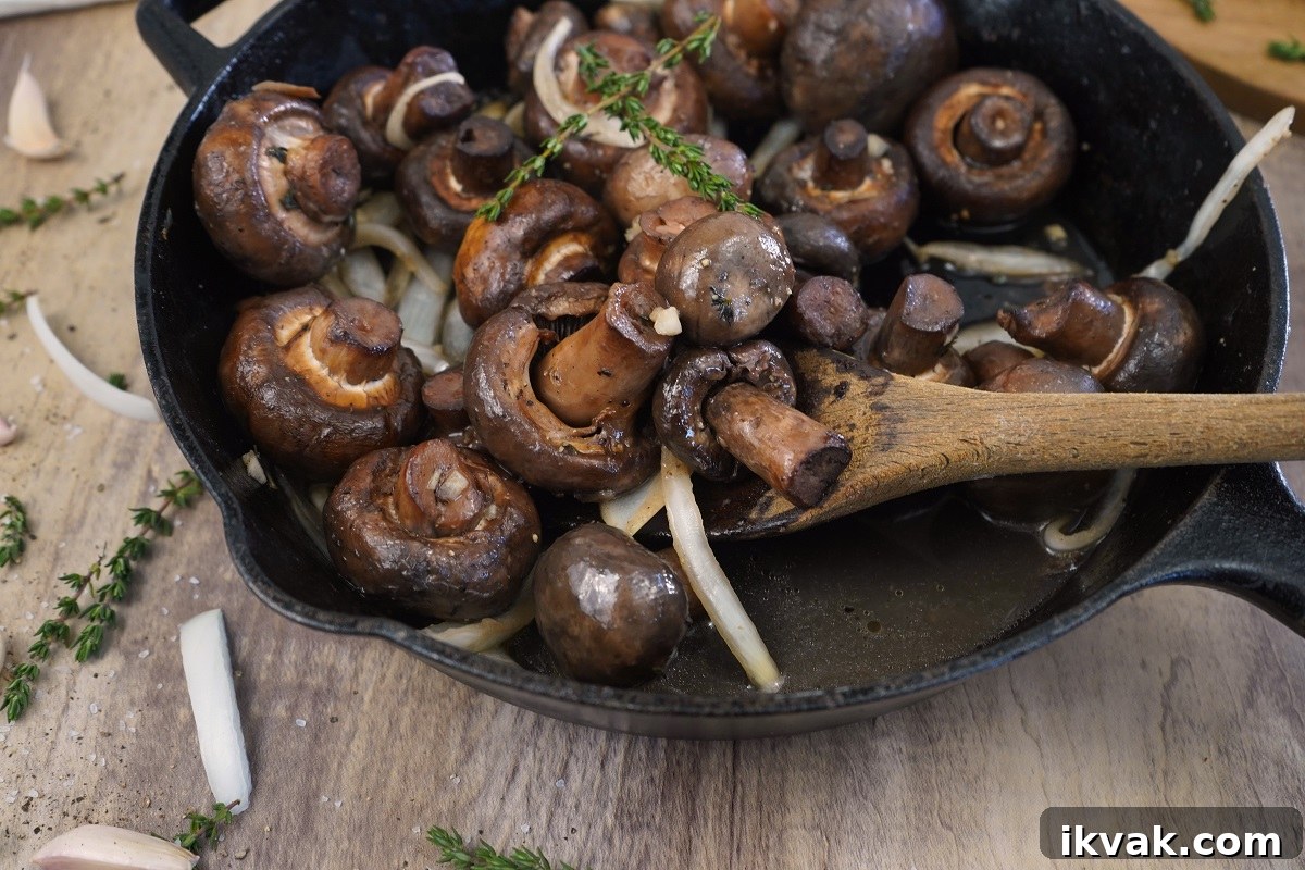 Garlic thyme smoked mushrooms with wooden spoon.