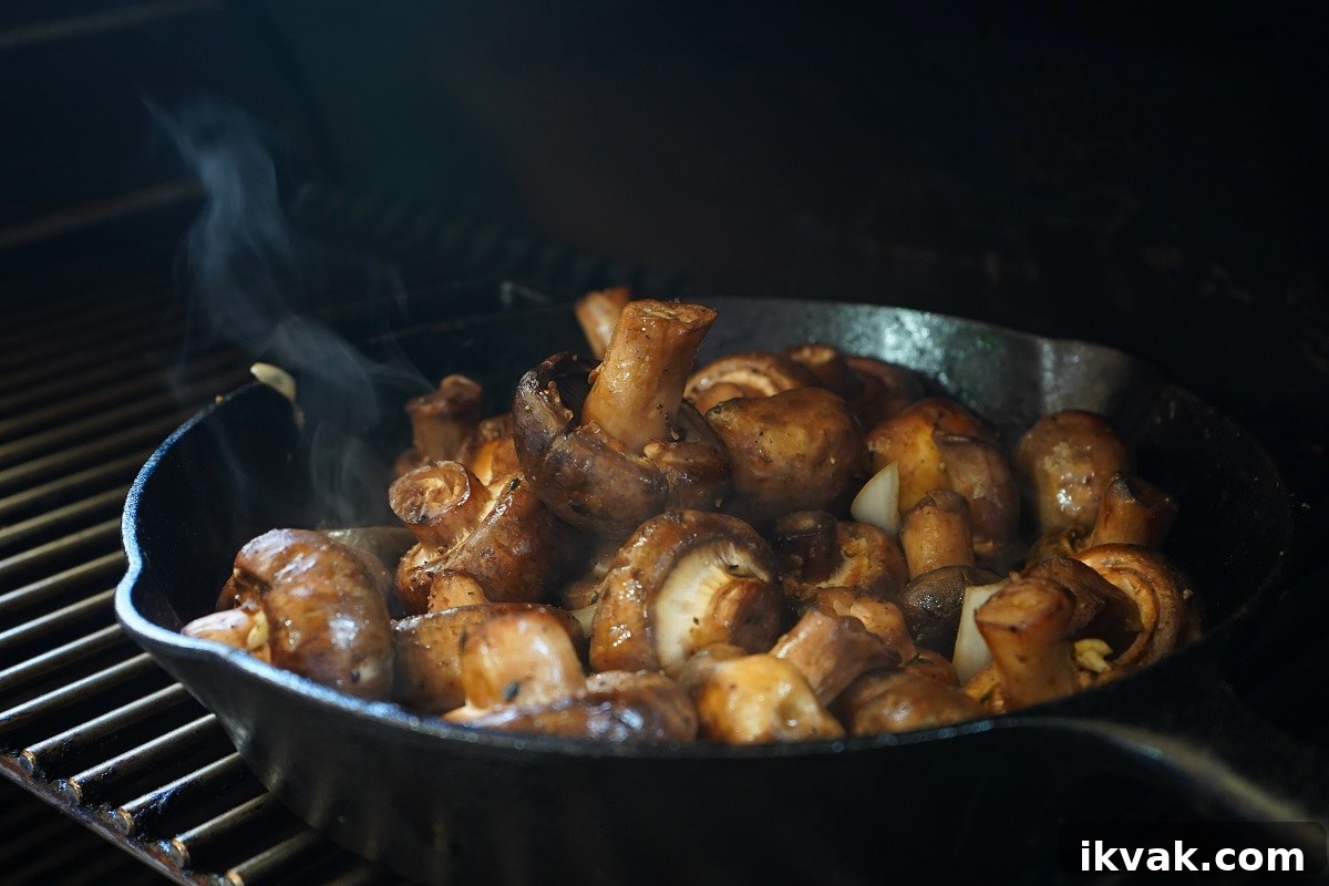 Smoked mushrooms on grill grates with smoke.