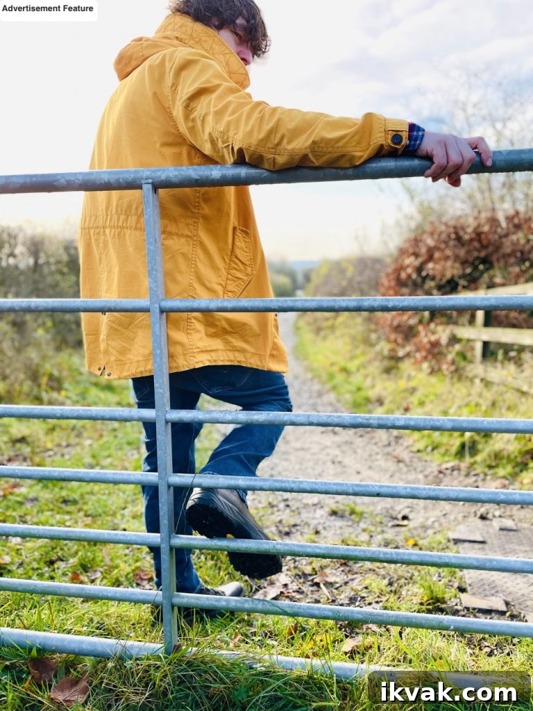 man leaning on a fence taking in the benefits of fresh air as he looks across the countryside 