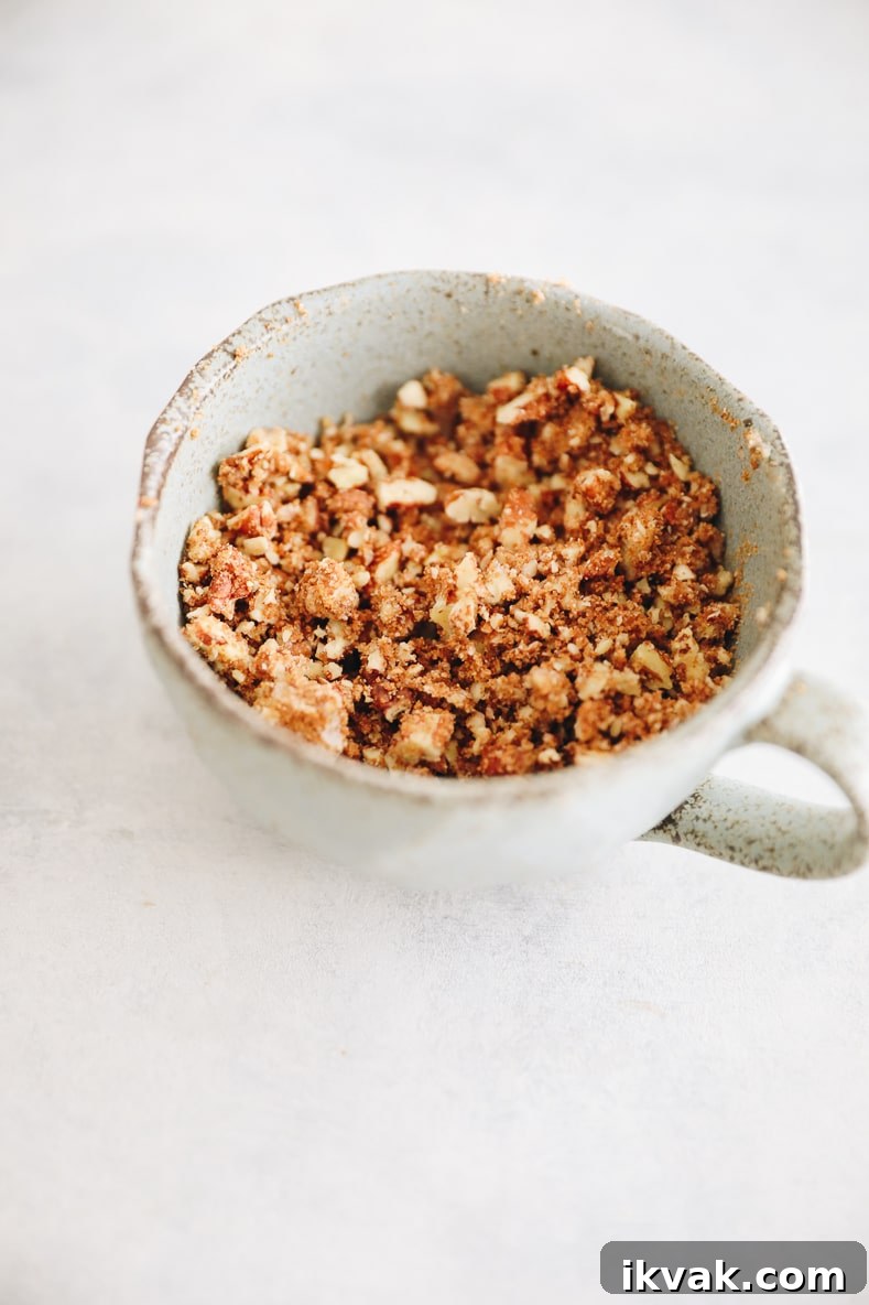 Blueberry Oat Muffins with Oats and Honey Crumble 3 Pecan streusel in a small blue cup.