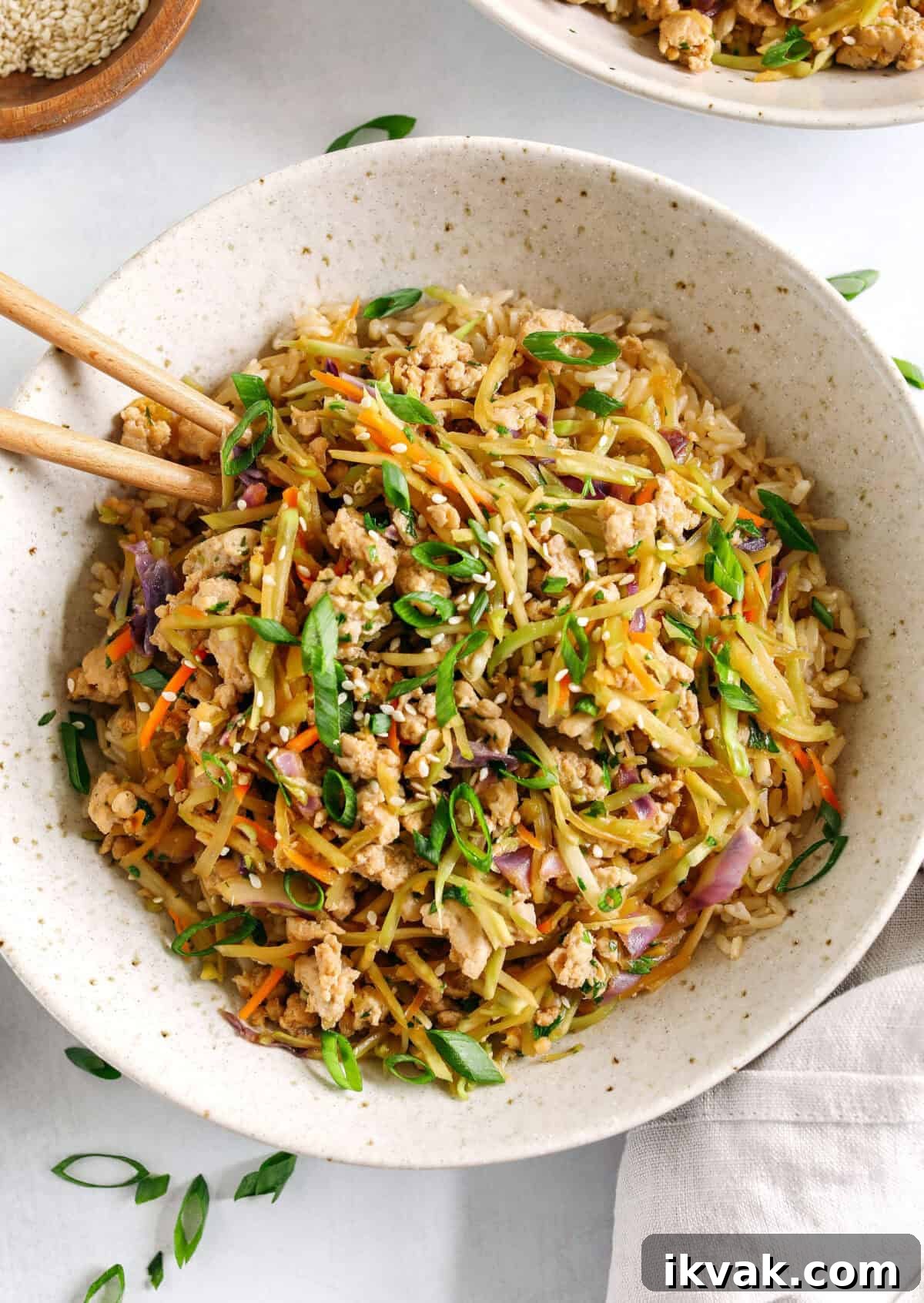 Easy and flavorful Chicken Egg Roll in a Bowl that comes together in under 20 minutes packed with so much flavor!  Perfect healthy weeknight dinner served over rice and garnished with green onions and sesame seeds.