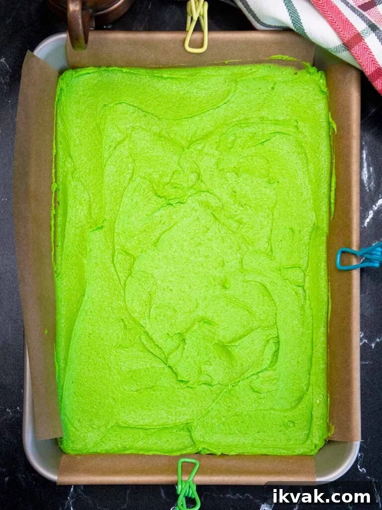 Green cookie dough in the parchment paper lined pan.