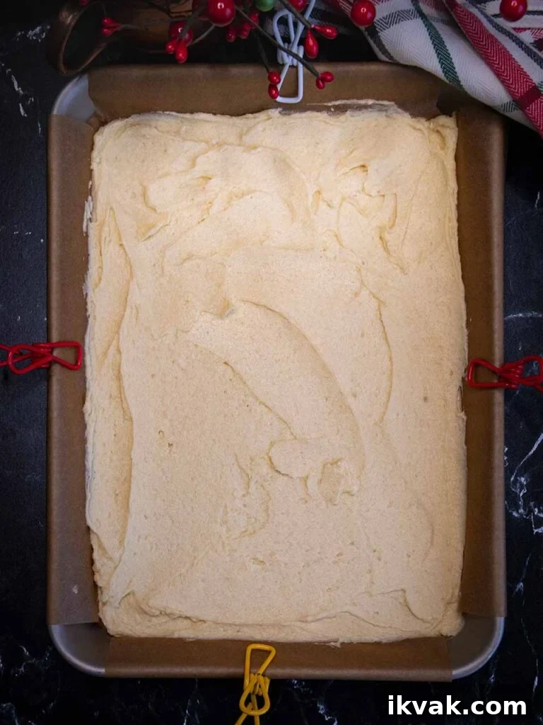 White cookie dough in the parchment paper lined pan.