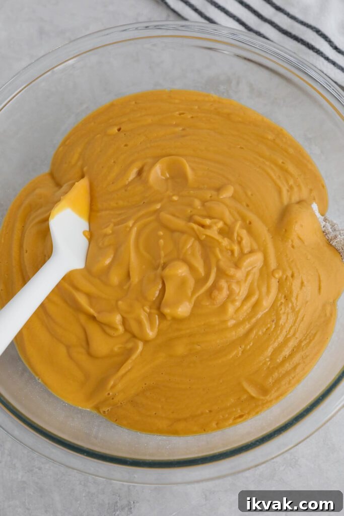 ingredients for sweet potato waffles in bowl with spatula