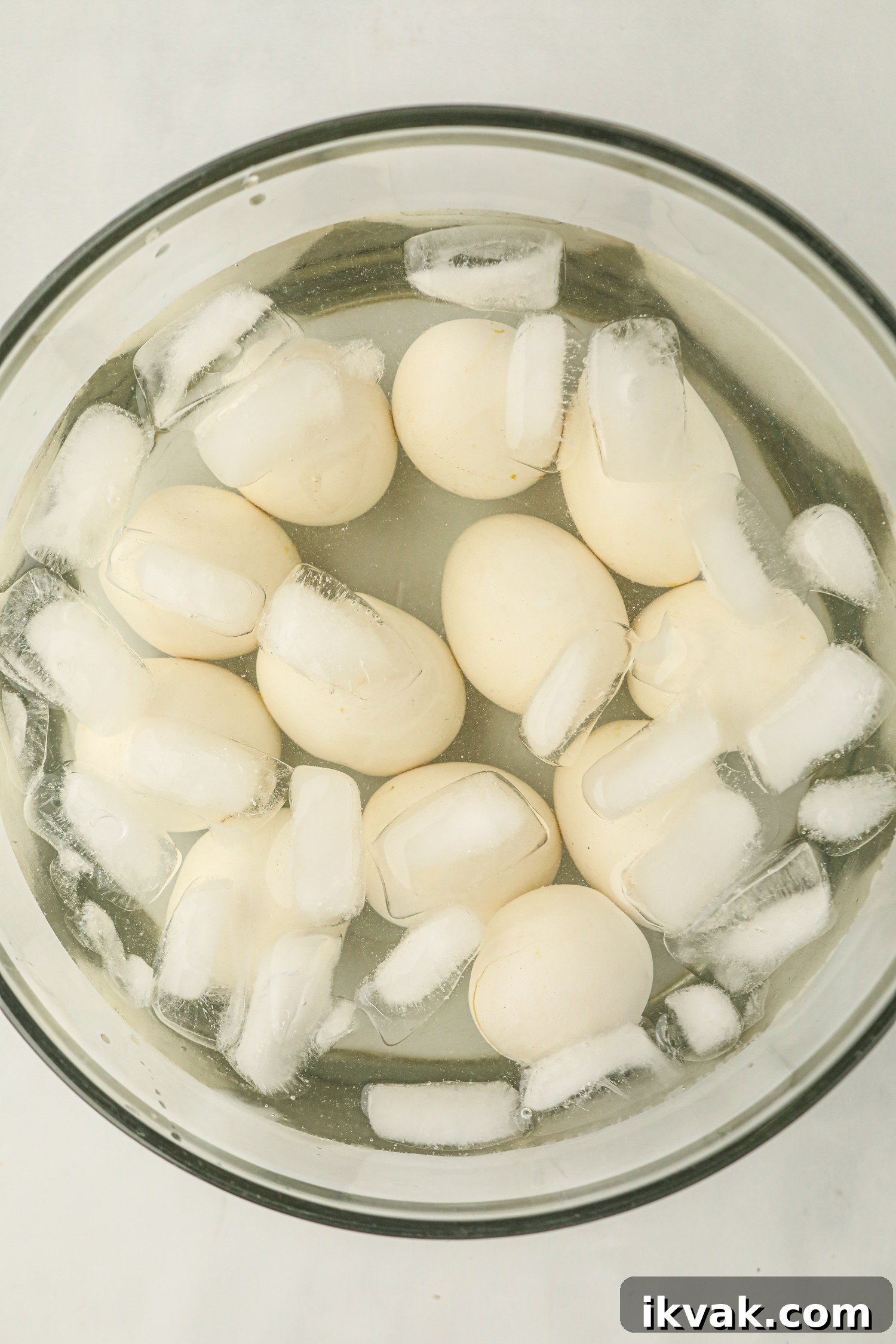 A glass bowl filled with smoked eggs in an ice water bath.