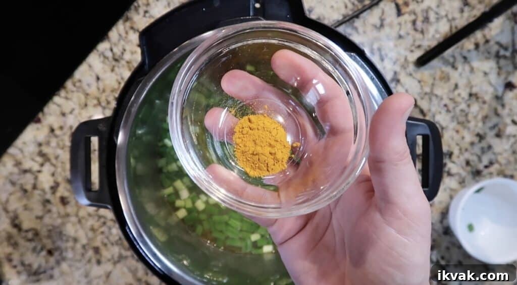Adding turmeric to the soup.