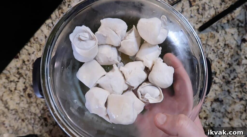 Adding frozen wontons to the soup
