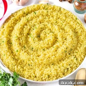 Yellow couscous with spices served on a white plate