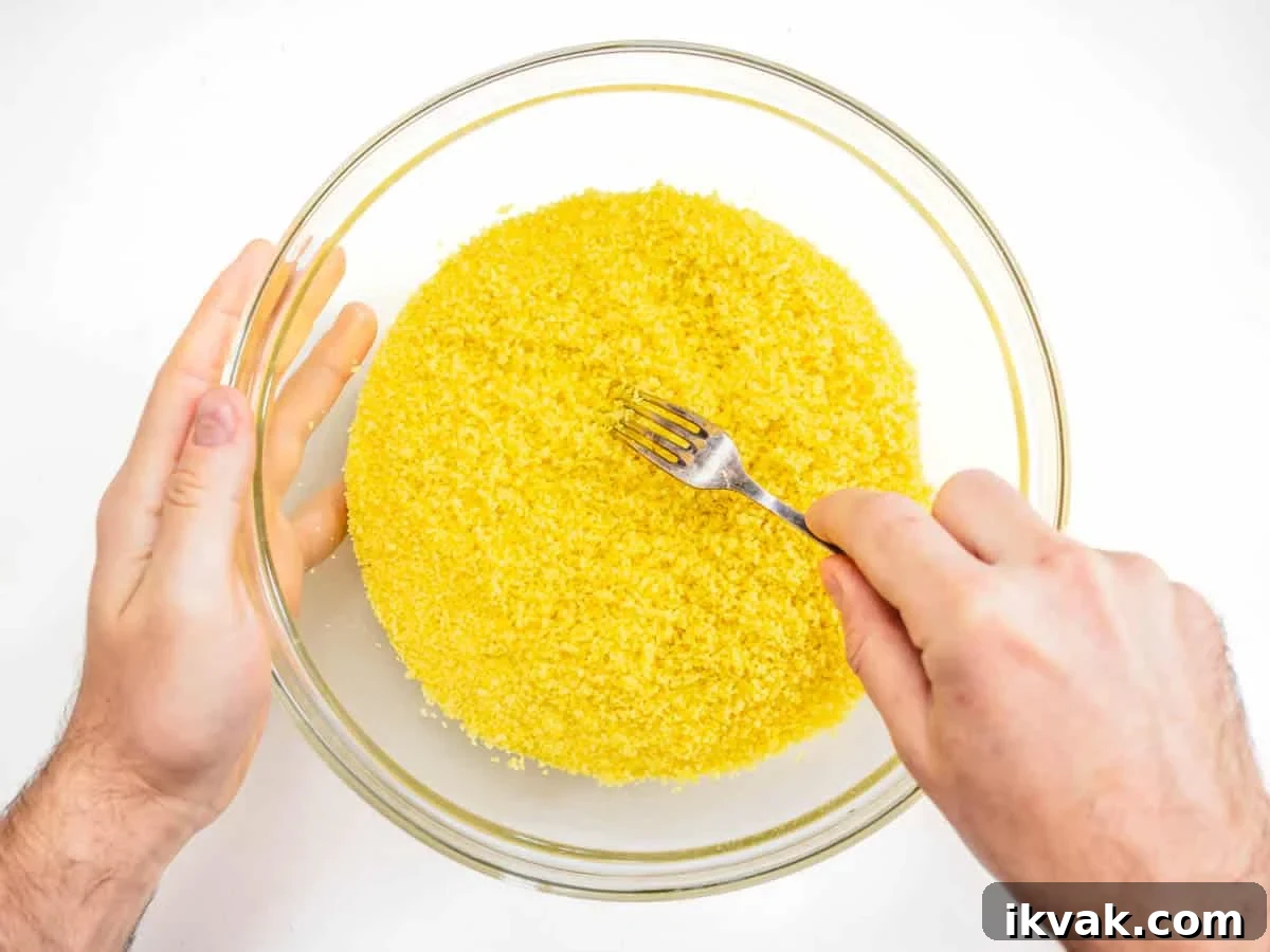 raking the couscous with a fork to fluff it up