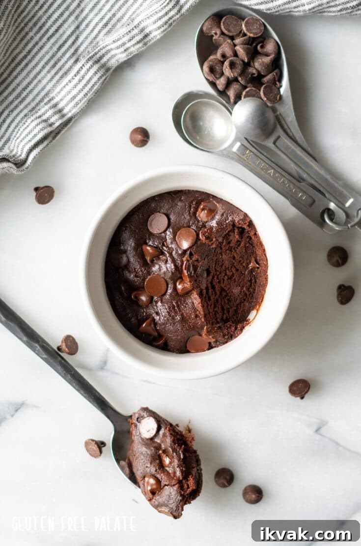 top down view of a mug cookie in a white ramekin with a bite out