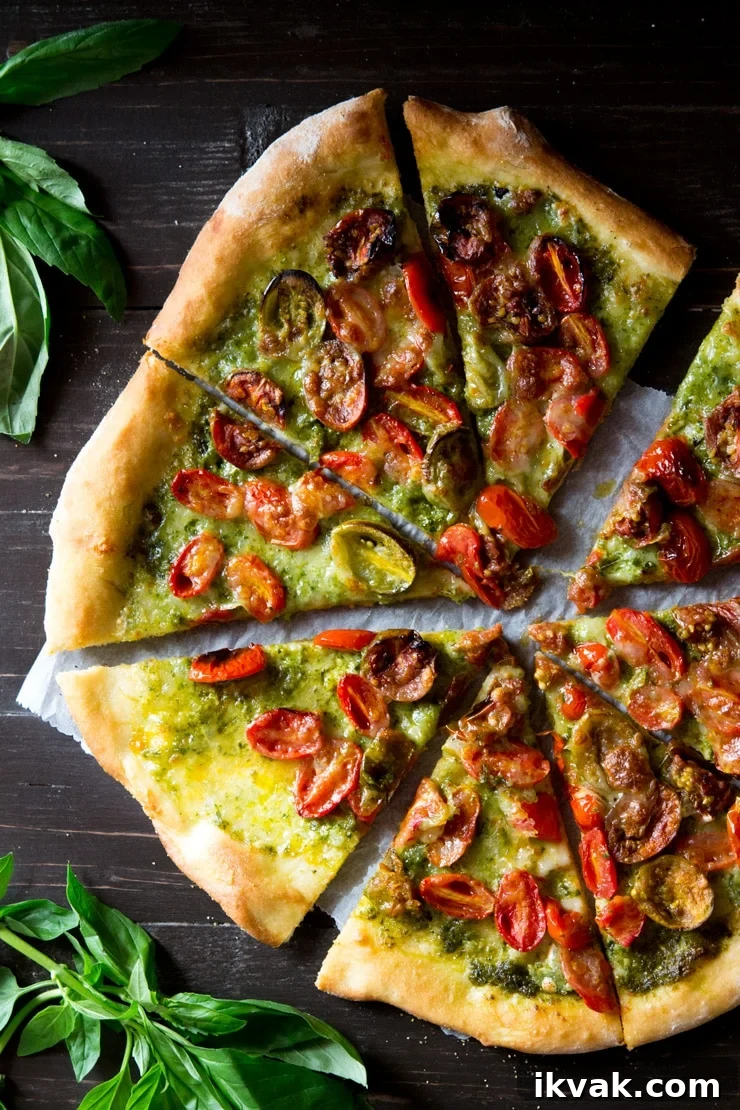 basil pesto pizza topped the cherry tomatoes and mozzarella cut into slices on a wooden board with basil