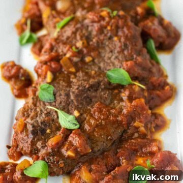 Steak alla Pizzaiola Recipe: Tender Beef in Tomato-Herb Sauce 15 Steak pizzaiola on white plate with oregano.