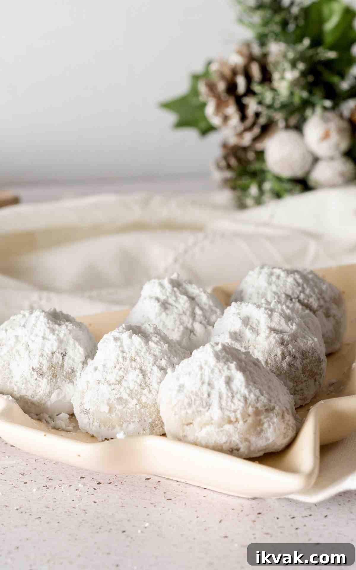 Chocolate chip snowball cookies on a Christmas tree shaped plate.