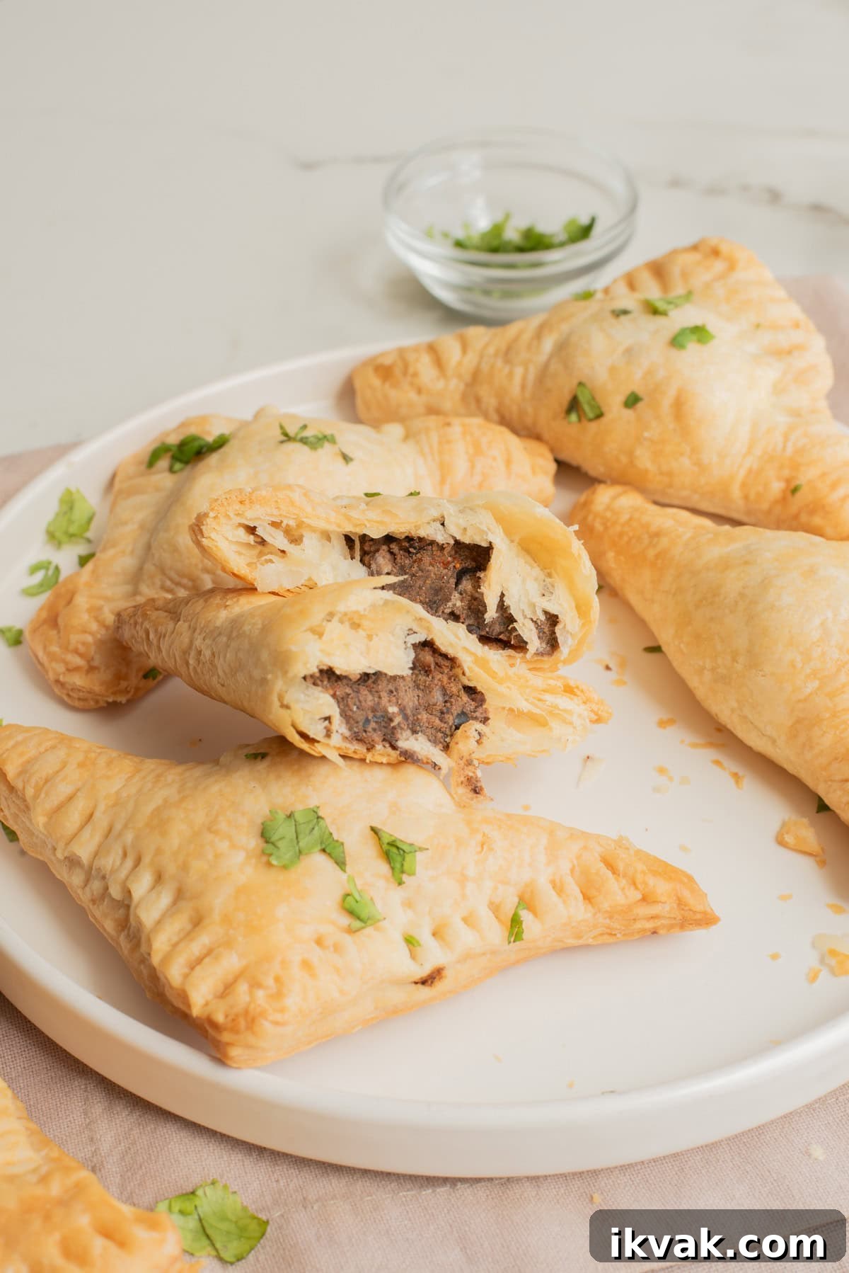 A plate of patties with one cut in half to show the inside filling.