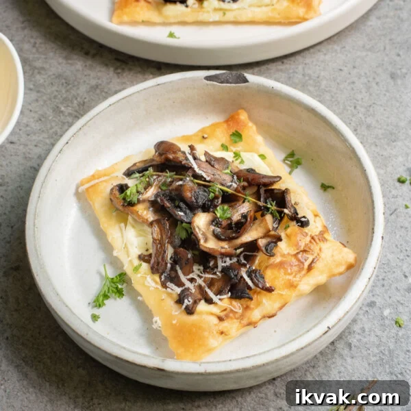 A close up image of a single mushroom tartlet on a serving plate.