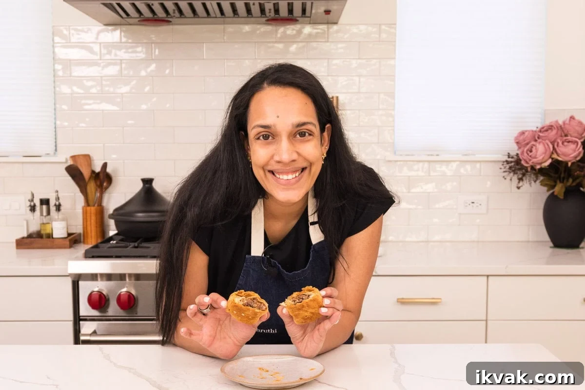 Shruthi holding cooked Jamaican black bean patties 
